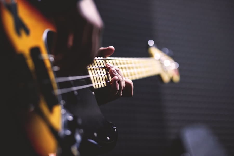 Mãos tocando guitarra elétrica em luz âmbar