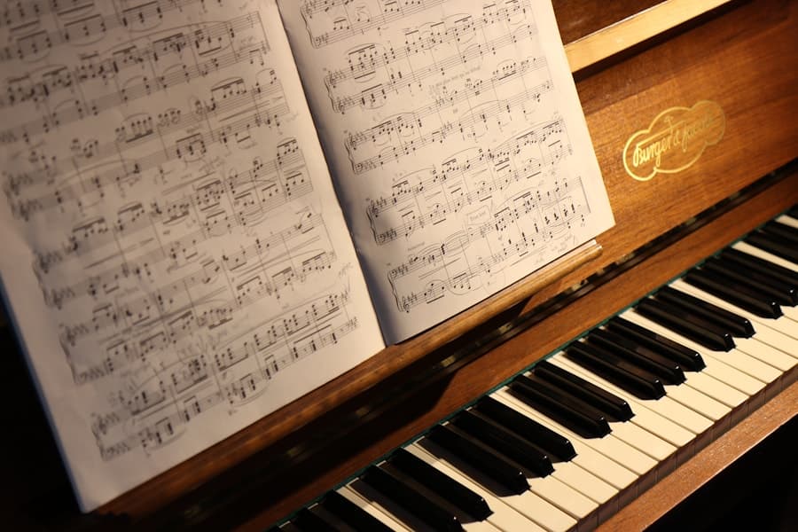 Mãos sobre as teclas de um piano de madeira