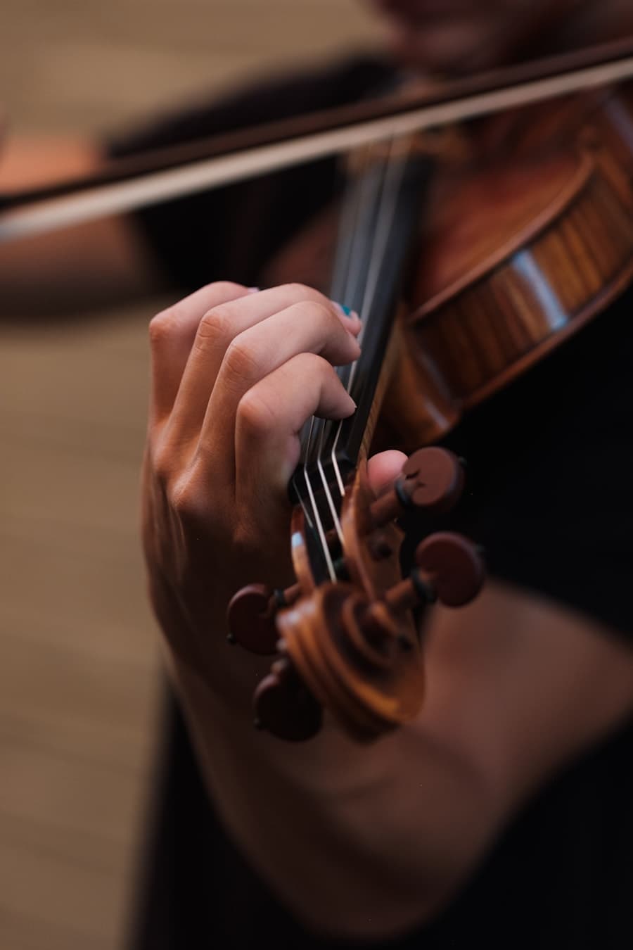 Mãos posicionadas no braço de um violino