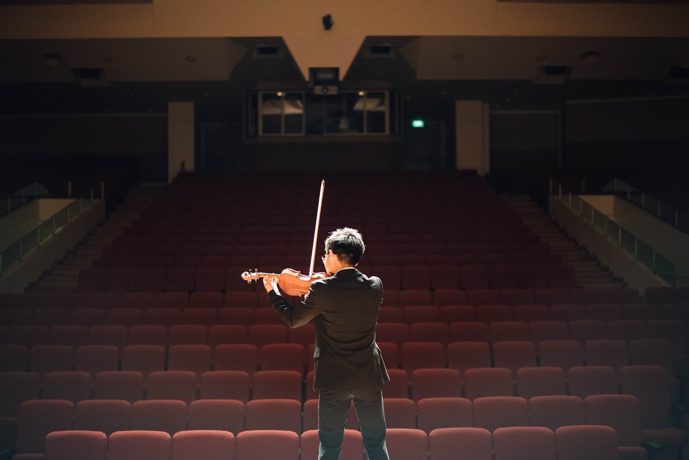 Músico solo tocando violão em um palco de igreja, com luz quente